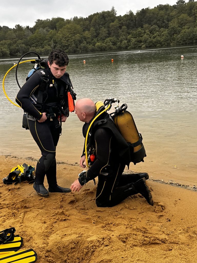 Un moniteur accompagne un plongeur au bord du lac